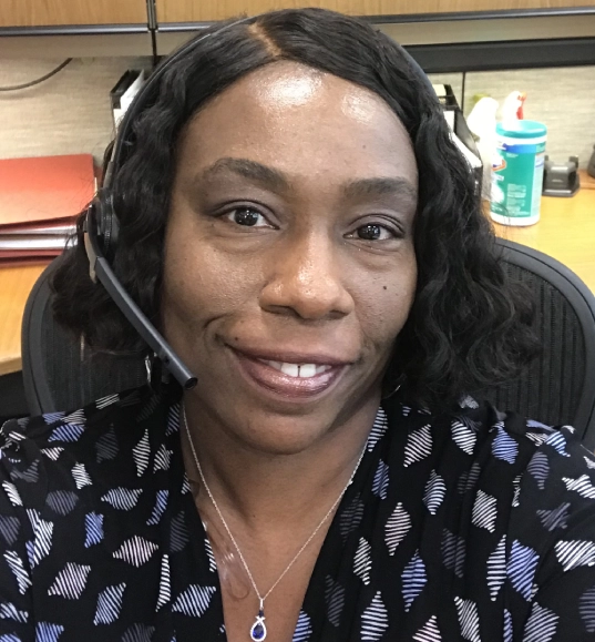 Smiling woman wearing a headset and necklace.